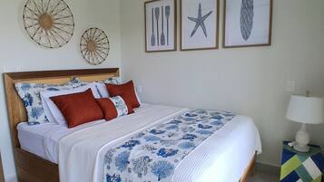 Un dormitorio con cama, ventilador de techo, aire acondicionado y decoración en la pared.