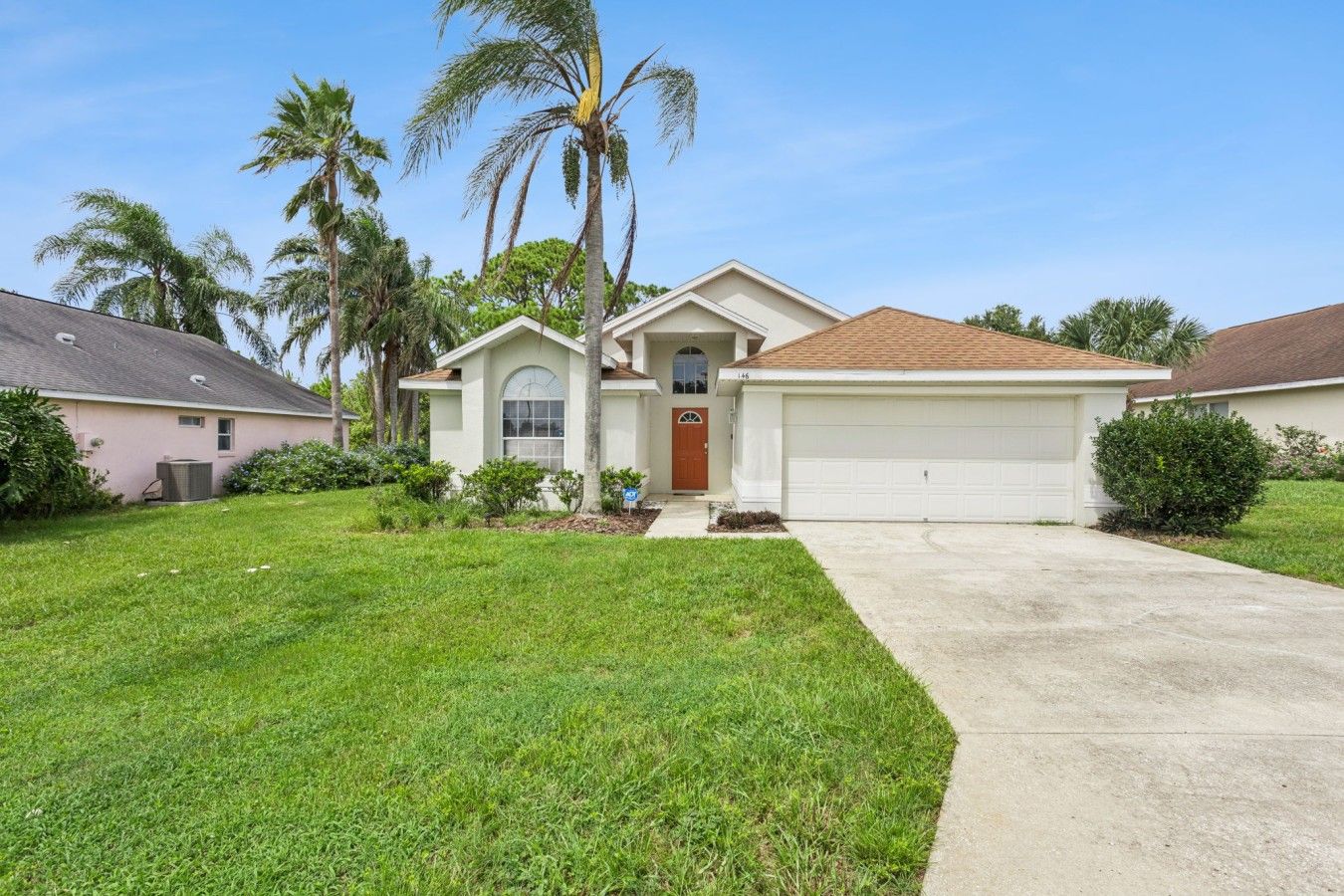 A residential house with a front yard, a garage, and a driveway.