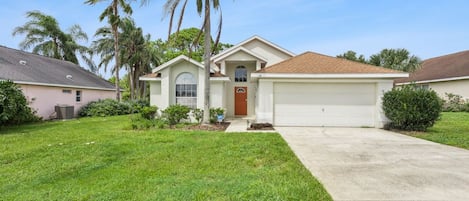 A residential house with a front yard, a garage, and a driveway.