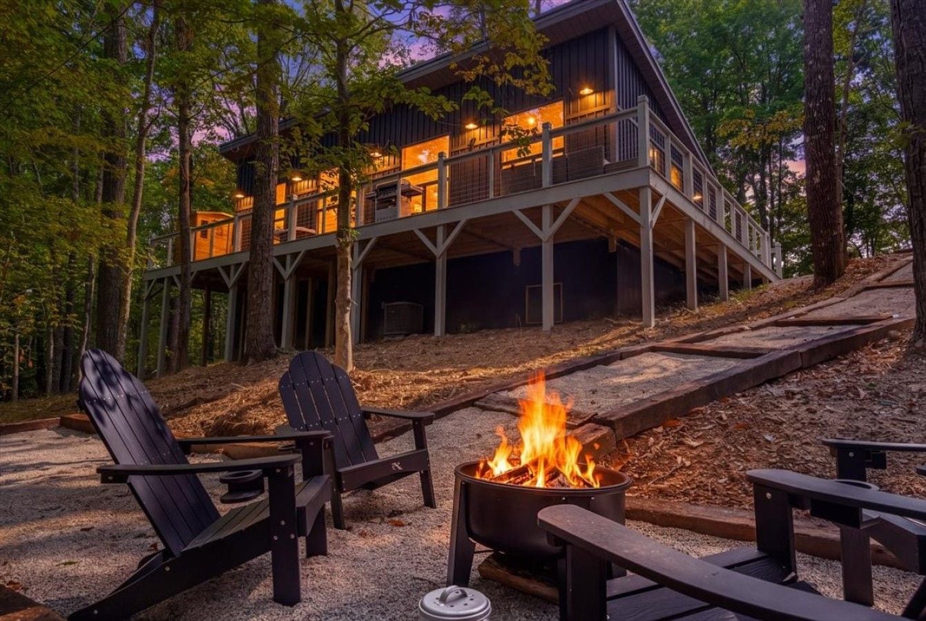 Une cabane avec un foyer et des sièges à l’extérieur.