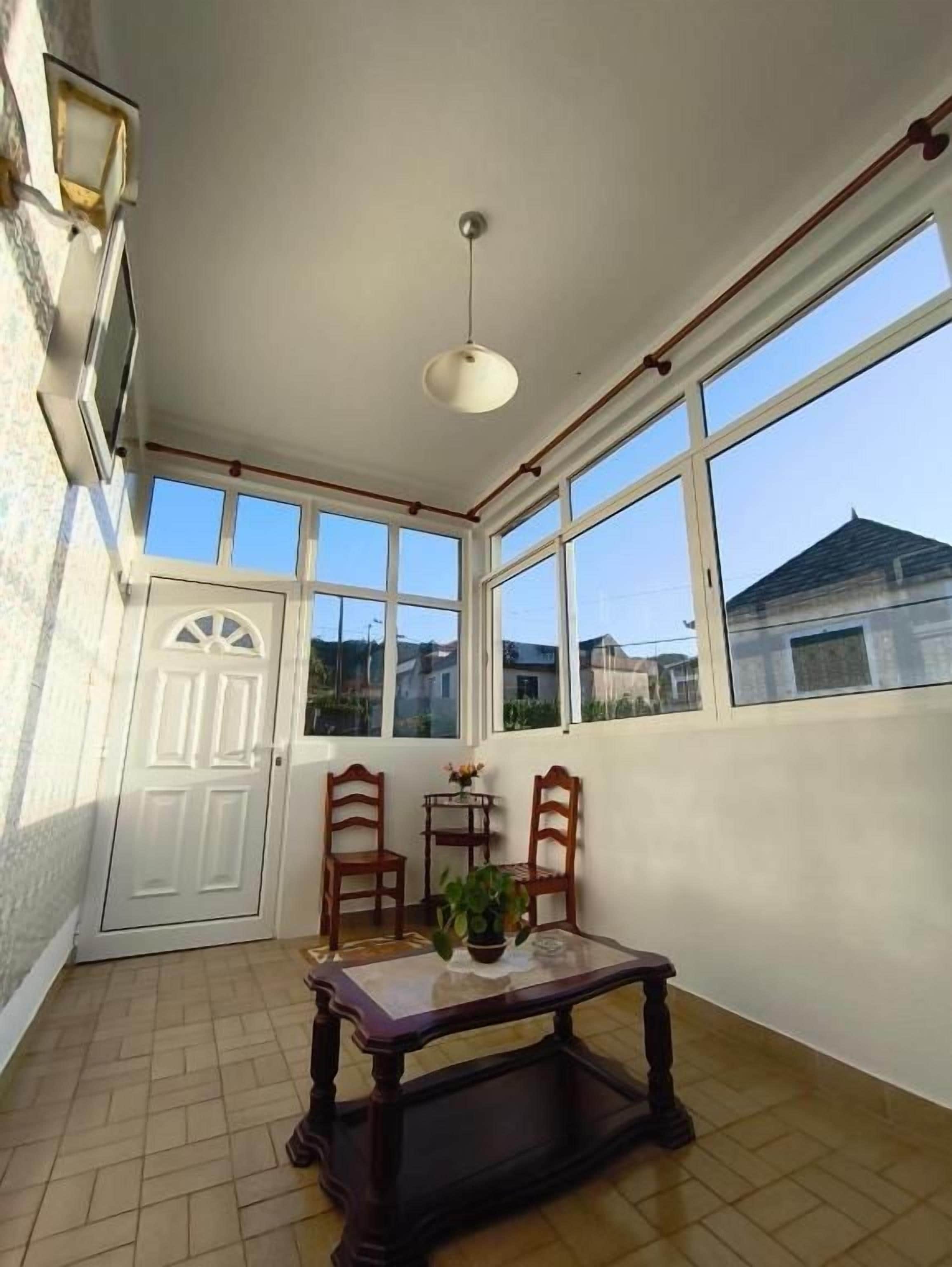 Une pièce baignée de lumière, avec une table, des chaises et une plante en pot.