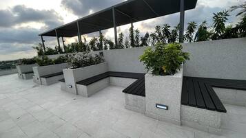 Outdoor seating areas with built-in planters and a covered walkway.