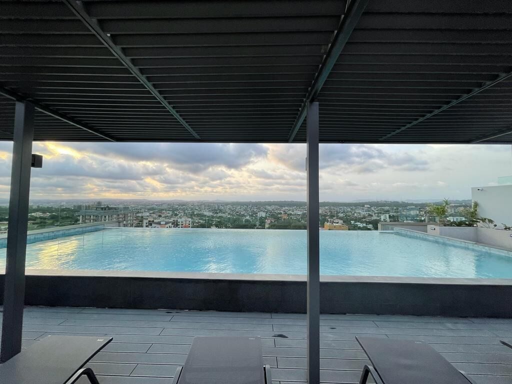 A rooftop pool with a view of a cityscape.