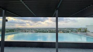 A rooftop pool with a view of a cityscape.