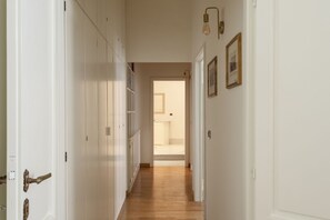 A hallway with white doors, a wooden floor, and a framed picture on the wall. - Porta Pia Enchanting Apartment (Roma)
