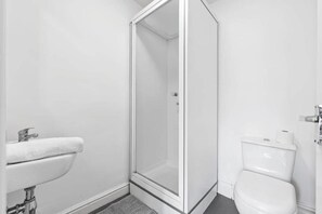 A bathroom with a shower, toilet, and sink. - Beautiful studio near Leeds City Centre - Room 6 (Leeds)