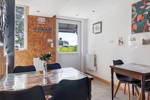 Un comedor con una pared de madera, una ventana con vistas y una mesa con sillas.
