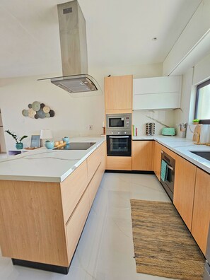 Eine moderne Küche mit Holzausstattung, Backofen und Mikrowelle.
