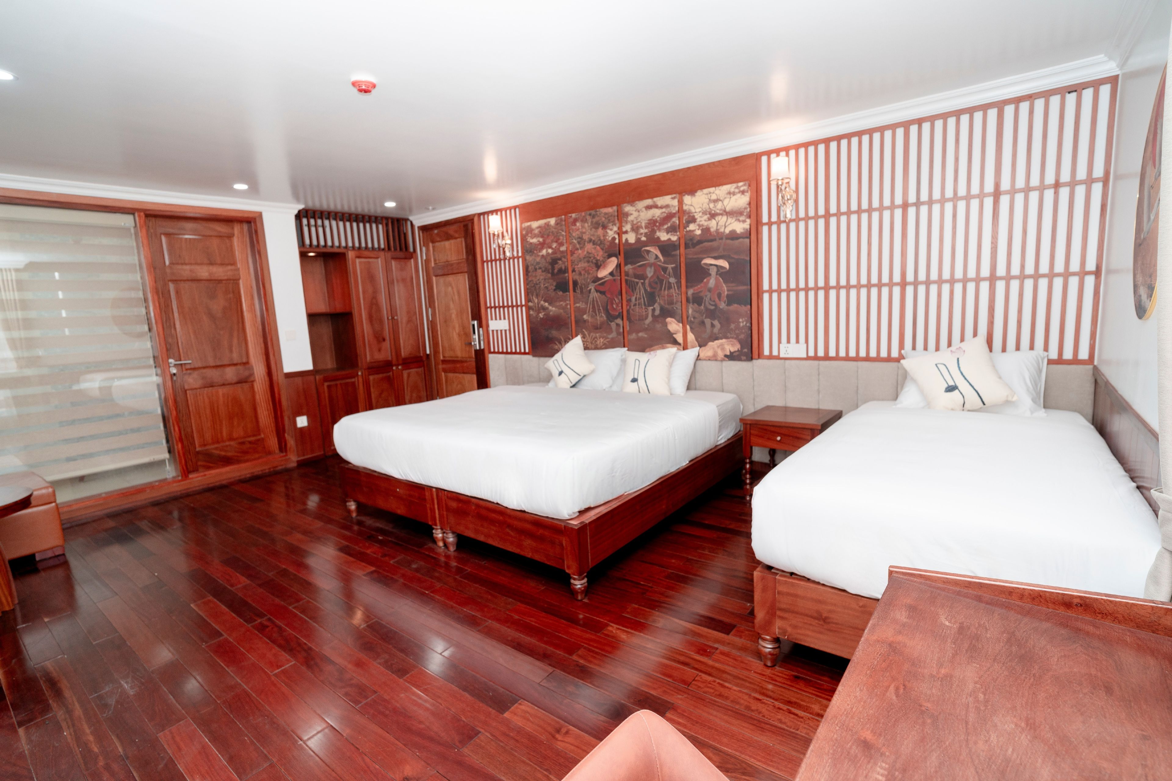 Een hotelkamer met twee bedden, houten vloeren, een groot raam met uitzicht en een traditionele Japanse wand.