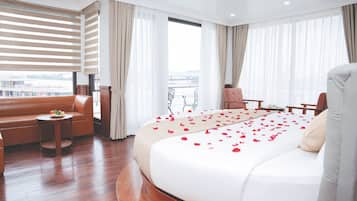 Habitación de hotel con una cama grande, un sofá, una mesita y una silla.
