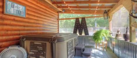 Una terraza de madera con un jacuzzi, un ventilador y un letrero.