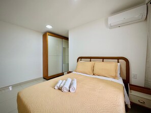 A hotel room with a bed, a mirror, and an air conditioning unit. - 2-bedroom apartment near 44th Street | Swimming pool | Garage | Air conditioning (Goiânia)