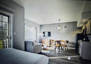 Ein modernes Interieur mit einer Couch, einem Esstisch, Stühlen und einer Küchenzeile.