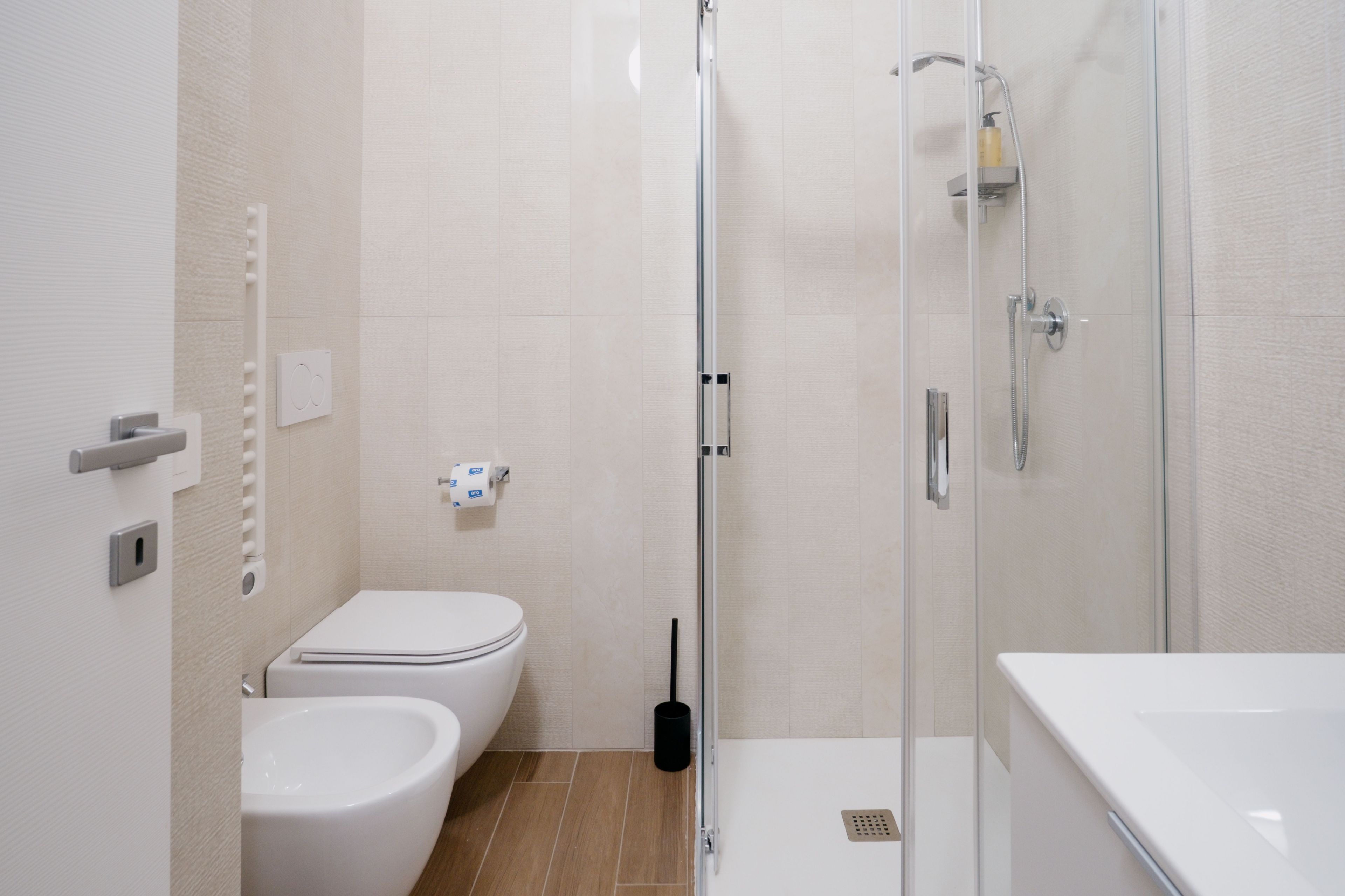 A modern bathroom with a toilet, bidet, and shower.