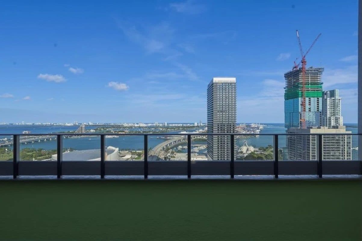 Un edificio de gran altura con vistas a un paisaje urbano y una masa de agua.