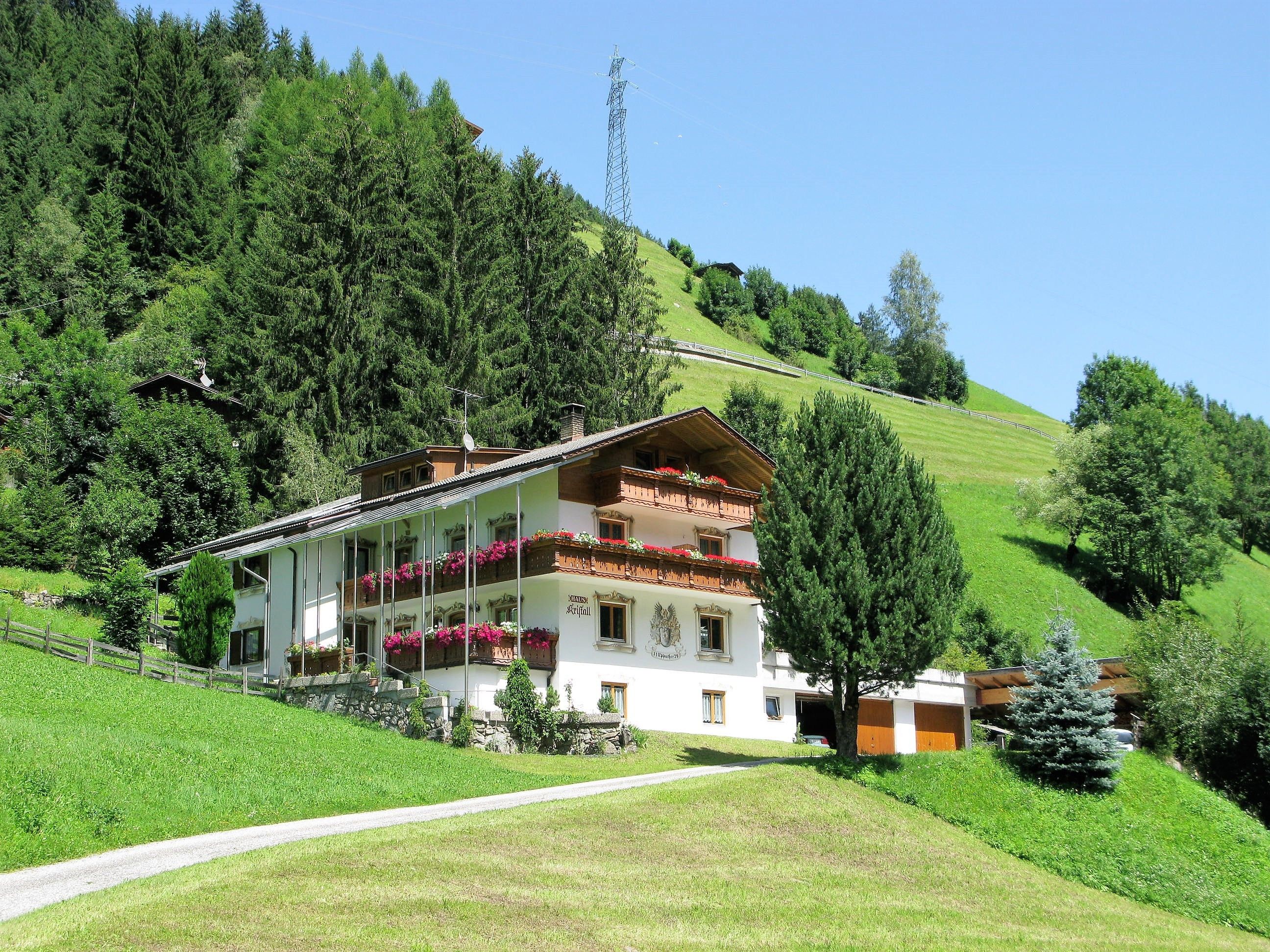 Un bâtiment à deux étages doté de balcons, entouré de verdure et surplombant un ciel dégagé.