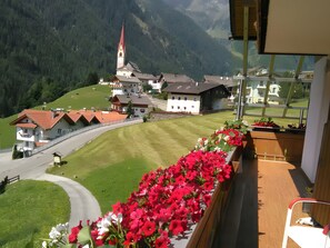 A mountain view with a church, houses, and a road.