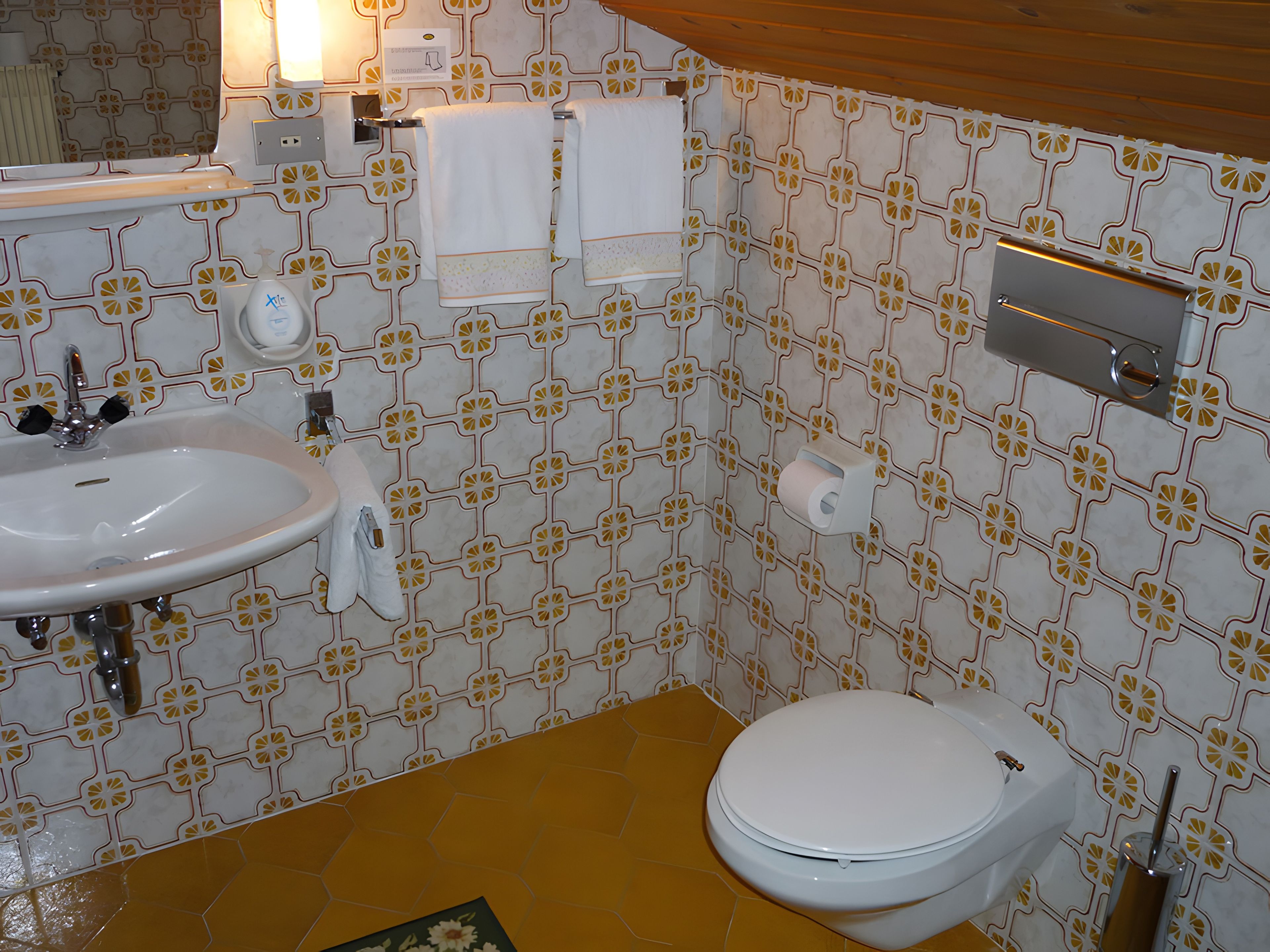 Ein Badezimmer mit weißem Waschbecken, Toilette und Handtuchhalter.