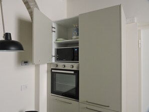 Une cuisine équipée d’un four à micro-ondes, d’un four traditionnel et de placards.