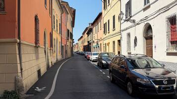 Eine schmale Straße, gesäumt von parkenden Autos und historischen Gebäuden.