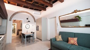 Uma sala de estar moderna com área de jantar, sofá, relógio e espelho.