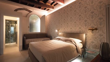 Una camera da letto con un letto, un tavolino in vetro e un angolo doccia.