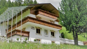 A multi-story building with balconies, surrounded by greenery. - Apartment '2' with Mountain View, Private Terrace and Wi-Fi (Selva dei Molini)
