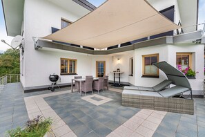 A covered outdoor patio with a grill, seating area, and a table. - Apartment 'Rackhof' with Mountain View, Private Terrace and Wi-Fi (Oberlienz)