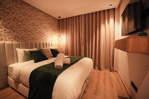 A modern bedroom with a large bed, a flat-screen TV, and a patterned wall. - Stylish 1BR apartment in central Casablanca with Terrace & Parking (Dar-el-Beida)