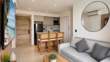 A modern living room with a sofa, a coffee table, and a dining area with chairs.