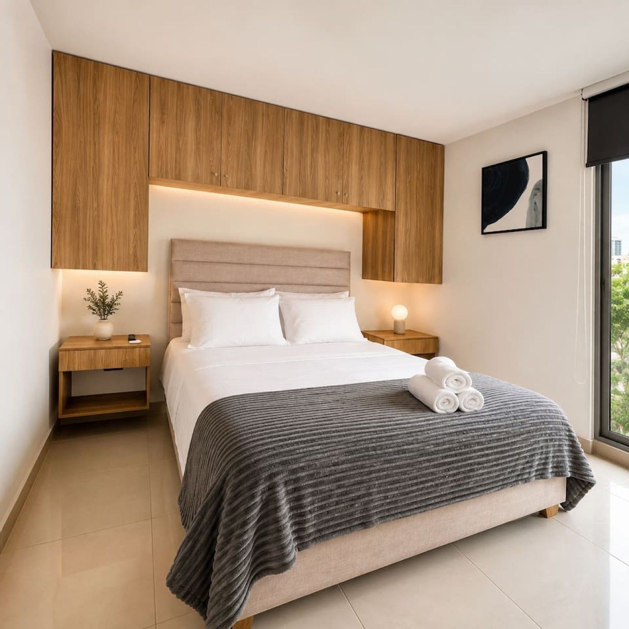 Un dormitorio moderno con una cama grande, cabecera de madera, mesitas de noche con lámparas y una ventana con vistas.