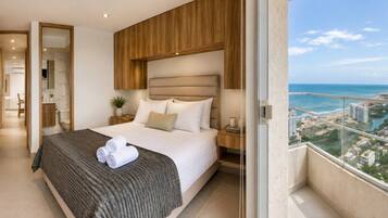 A modern hotel room with a large bed, a view of the city, and a balcony.