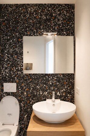 A bathroom with a white sink, a mirror above it, and a toilet with a white lid. - Don Filippo Luxury Home - Vesuvia (Naples)