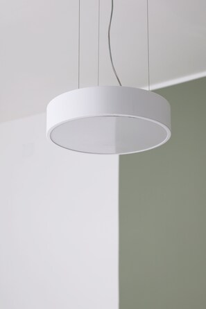 A white circular pendant light fixture suspended from the ceiling. - Don Filippo Luxury Home - Vesuvia (Naples)