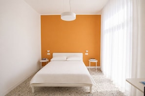Ein Schlafzimmer mit einem Bett, zwei Nachttischen und einer Pendelleuchte.