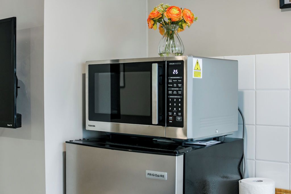 A kitchen with a microwave and a refrigerator.