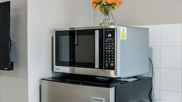 A kitchen with a microwave and a refrigerator.