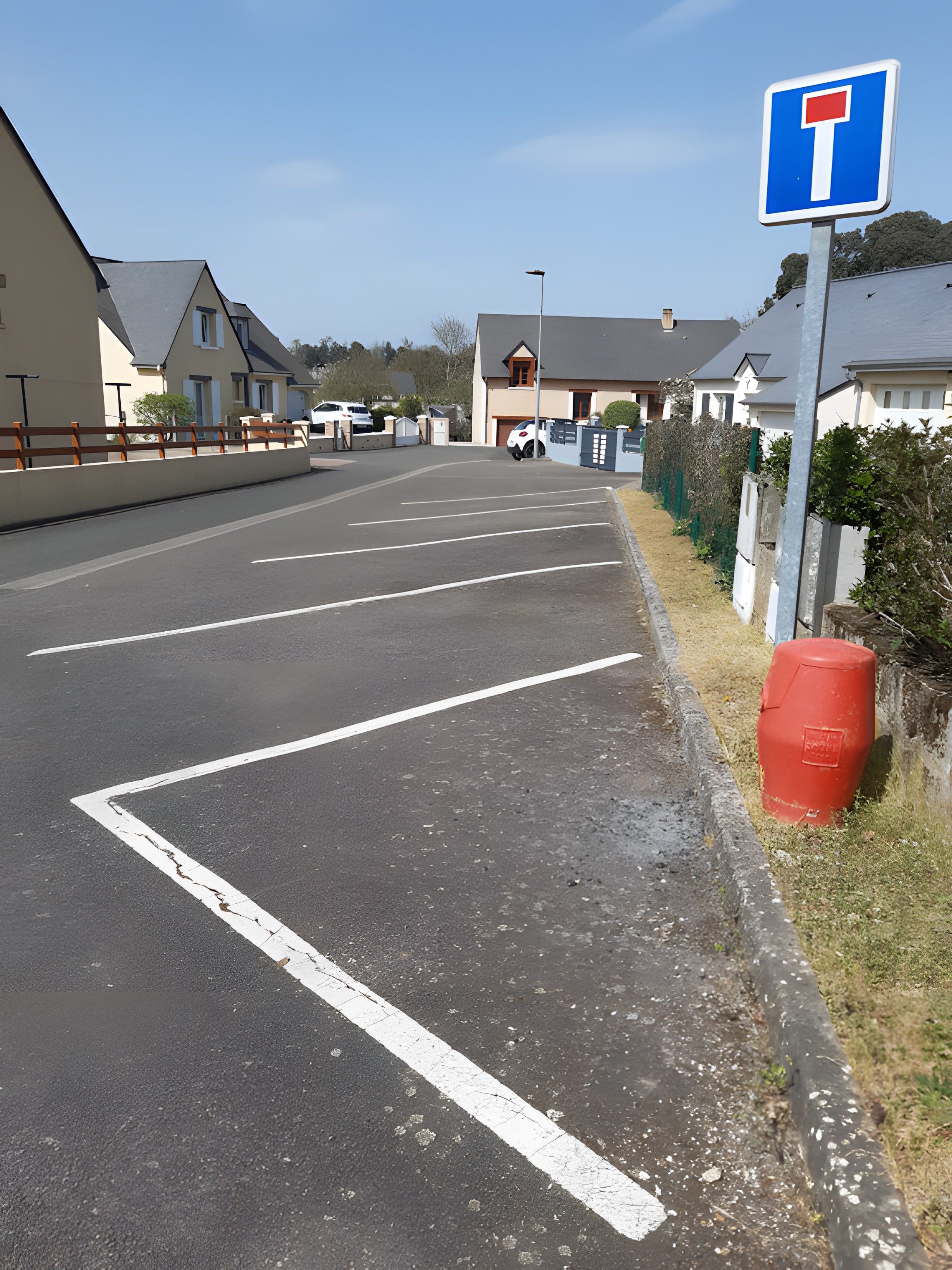 Un parking avec des voies clairement délimitées et un panneau de signalisation.