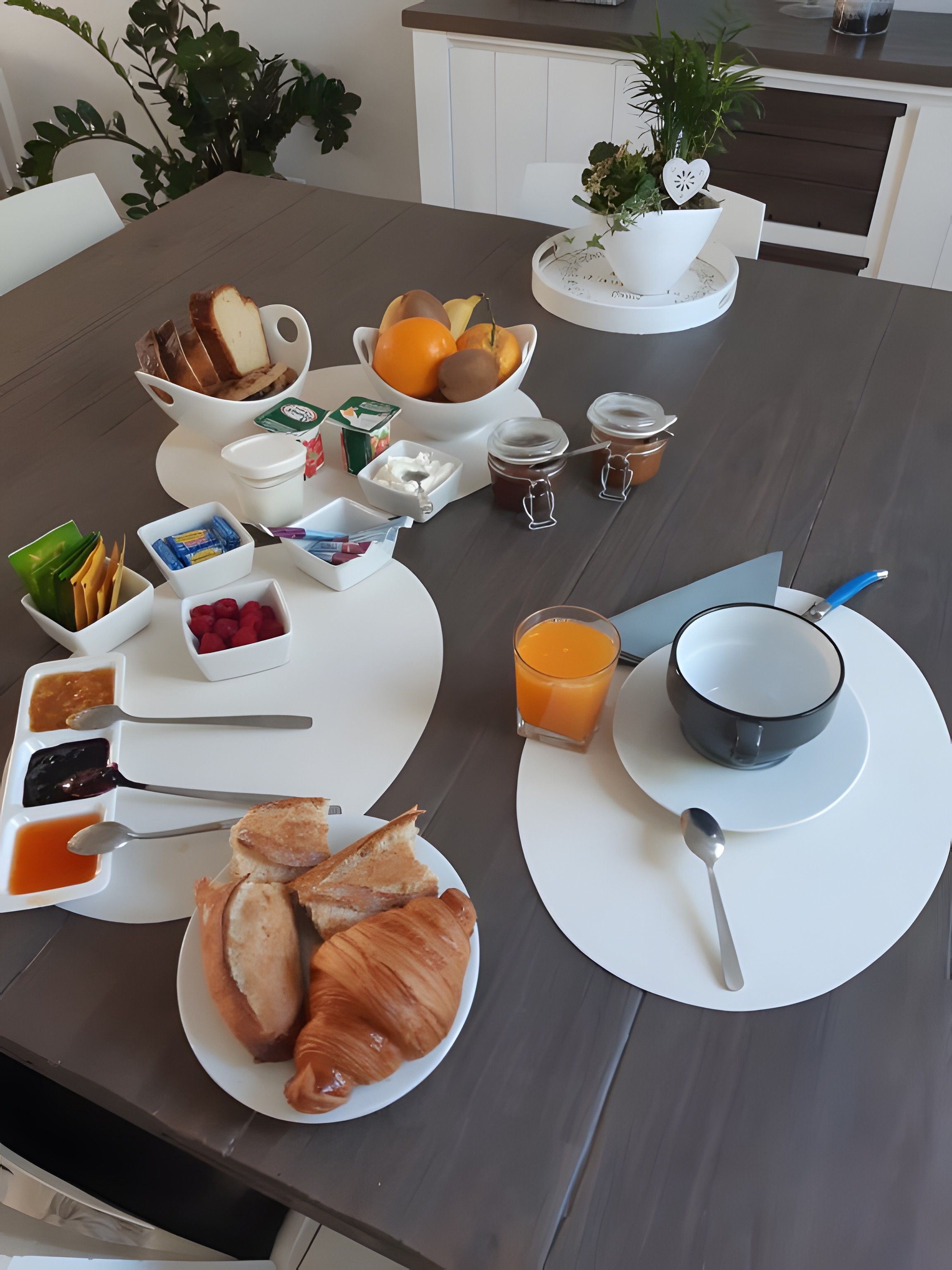 Una tavola imbandita per la colazione con dolci, frutta e salse.