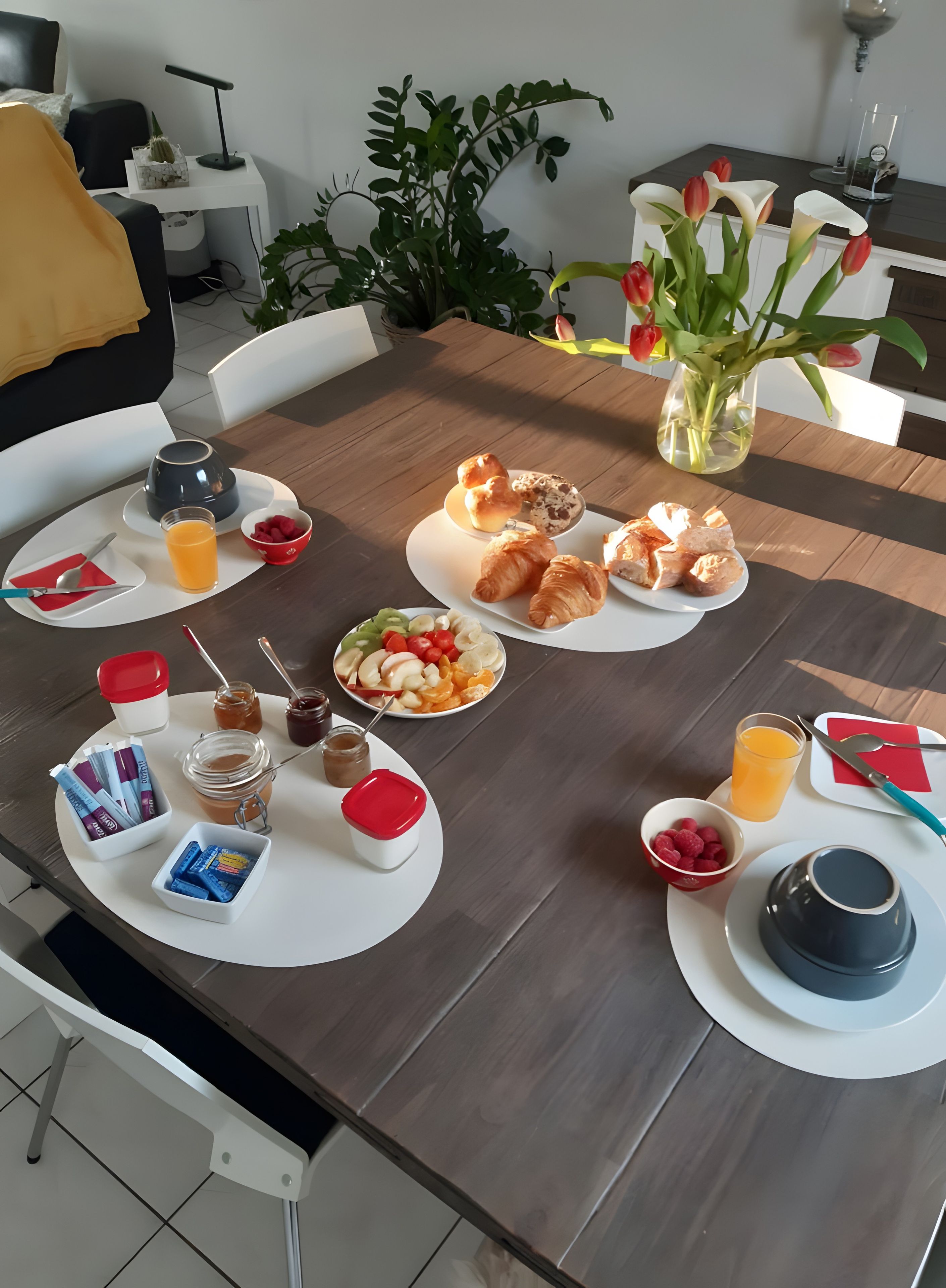 Une table dressée pour le petit-déjeuner, avec une variété d’aliments et une tasse de café.