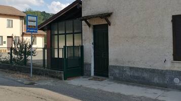 Un edificio con una porta verde, una finestra e un cartello che indica una fermata dell'autobus.