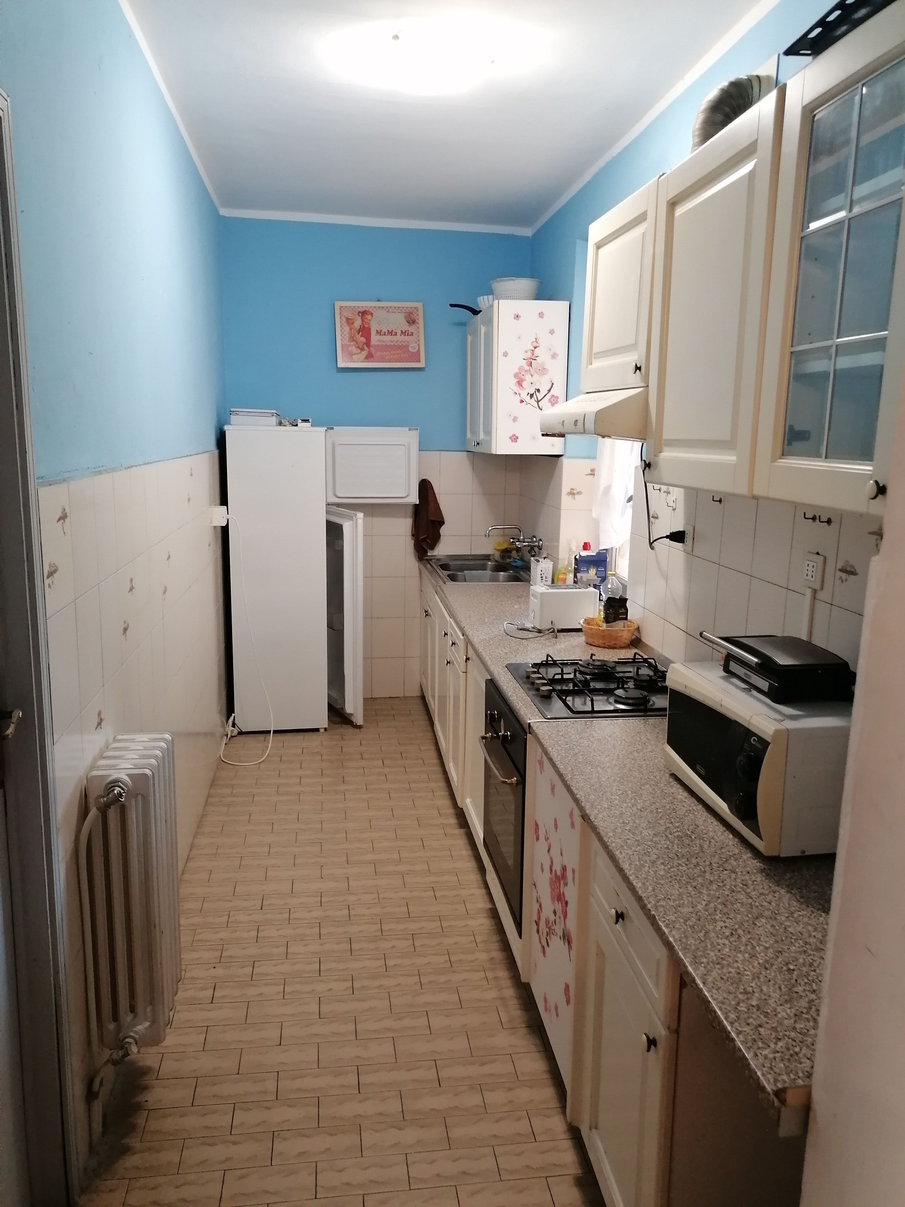 A kitchen with white cabinets, a refrigerator, a stove, and a microwave.