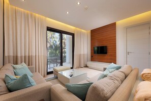 Ein modernes Wohnzimmer mit einer Sofagarnitur, einem Couchtisch und einem an einer Holzwand befestigten Fernseher.