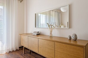 Eine Holzkonsole mit einem Spiegel darüber, einer Vase mit Trockenpflanzen und zwei dekorativen Eiern auf der Konsole.