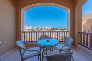 Ein Balkon mit Korbmöbeln und Blick auf Gebäude.