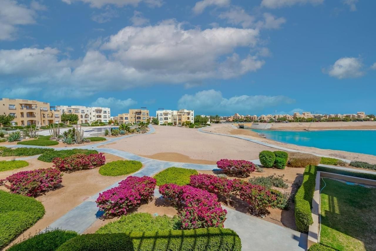 A resort with a pool, landscaped gardens, and buildings in the background.