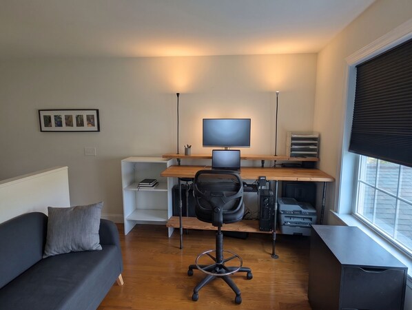 Un espace de bureau moderne comprenant un bureau, une chaise, un ordinateur et une imprimante.