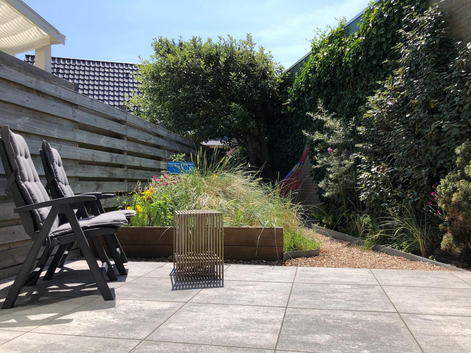 Eine Terrassenfläche mit Sitzgelegenheit und einem Blumenkasten.