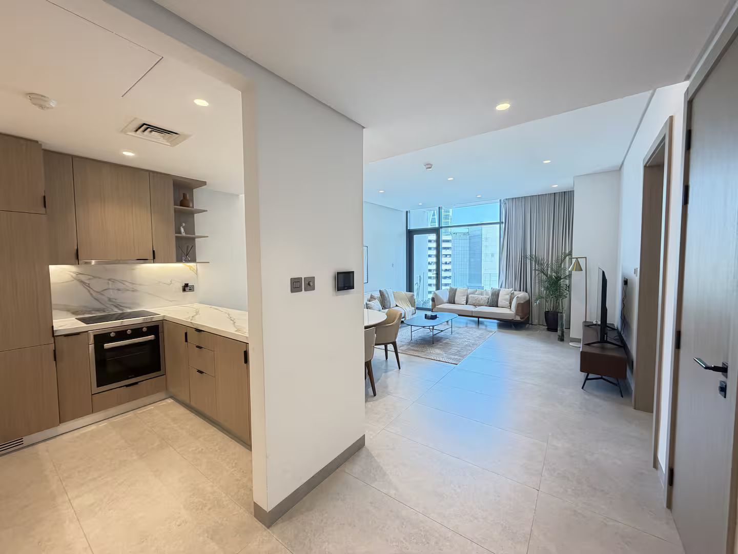 A modern apartment with a kitchen, dining area, and living room.