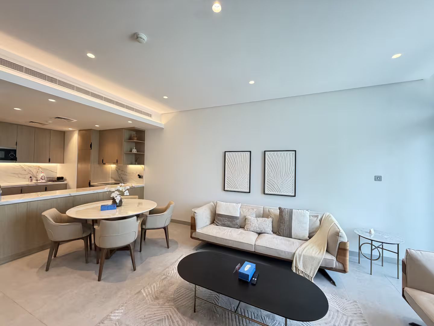 A modern living room with a round dining table, a sofa, and a coffee table.